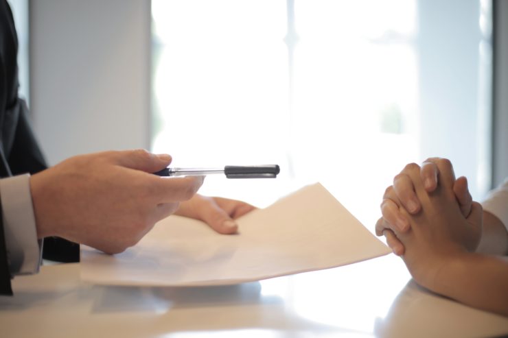 Signing a licence application across a desk